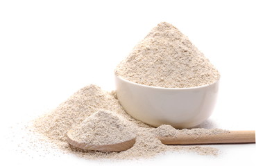 Integral barley flour pile with wooden spoon and porcelain bowl isolated on white background, clipping path