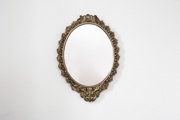 Golden antique mirror on white wall background texture