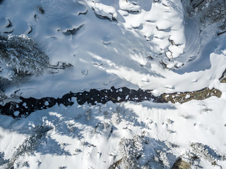 Fototapeta na wymiar Aerial view of river thorugh snow covered forest in calm scene