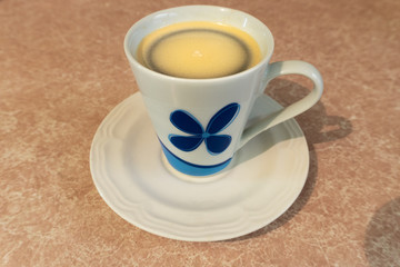 Black coffee with cream in a cup.