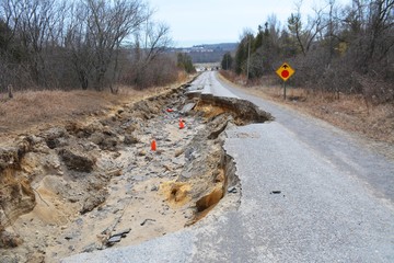 Payment collapsed by erosion destroys road.