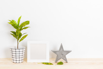 Home decor with picture frame, concrete star and plant © Studio Light & Shade