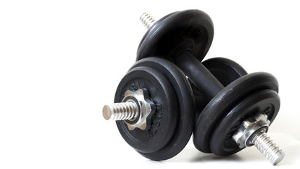 Pair of black dumbbells weights isolated on or over a white background. Fitness, bodybuilding and healthy lifestyle concept. Fitness exercise equipment dumbbells. Copy space for text. Clipping path.
