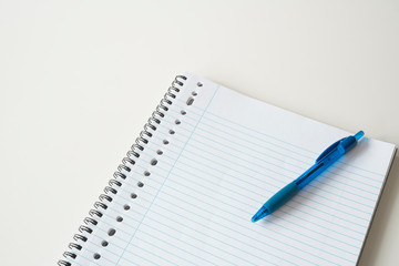 flat lay blue pen, empty spiral note book, white background, space for text