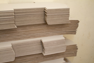 Many large stacks of brown paper against the background of recycled materials.