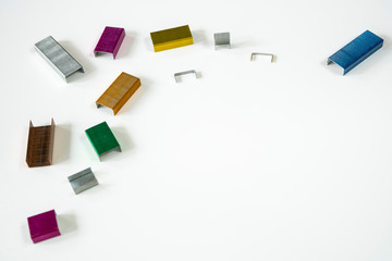 flat lay border colorful staplers in green, gold, copper, blue, purple and yellow, space for text