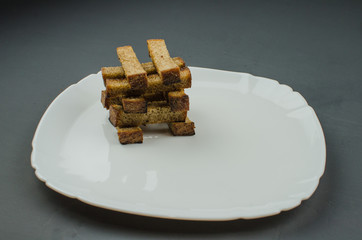 Toasts are fried on a frying pan with spices. Served on a white plate with garlic sauce and barbecue sauce