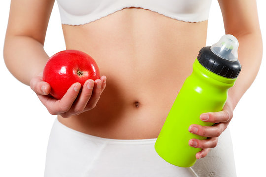 close up woman stomach with hands holding water and reg apple isolated on white