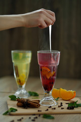 hand stirs hot steaming tea in glass. winter hot seasonal drinks