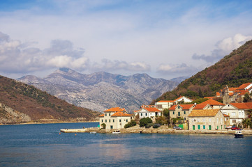 Fototapeta na wymiar Beautiful Mediterranean landscape. Small seaside village at the foot of the mountains. Montenegro, Adriatic Sea, Bay of Kotor, Lepetane village