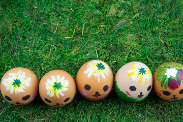 kawai eggs stand in a row on green grass for easter