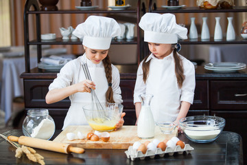 two girls make flour dough.