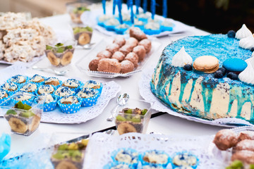 Beautiful variety of sweets on table with blue decorations