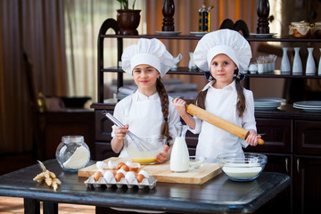 two girls make flour dough.