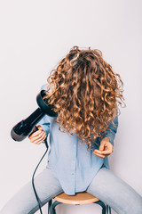 Young woman sitting on chair styling