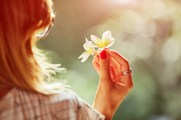 Portrait of beautiful woman holding frangipani flowers.