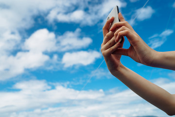 Phone in hand on blue sky