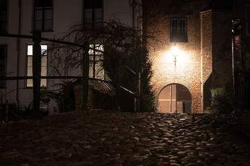 Medieval city gate with old pavement and atmospheric lighting
