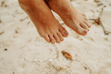 Woman sitting on palm tree at tropical beach