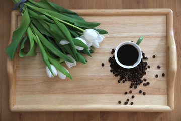 tulips and coffee on wooden board