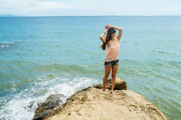 Girl standing on coastal sea rocks. Well being healthy lifestyle. Mindoro, Philippines