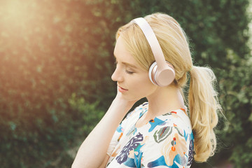 View of young Caucasian woman listening to music and being inspired in an outdoor setting