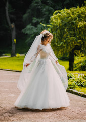 Fototapeta premium Sweet bride in a white dress .whirl in the park