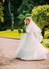 Cute bride in a white dress .whirl in the park