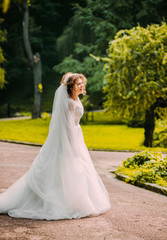 Pretty bride in a white dress .whirl in the park