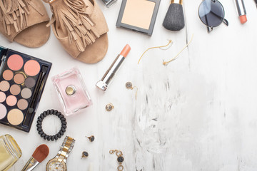 Beauty concept in a blog. Professional female make-up accessories, watch, bracelet, lipstick, brush, powder, on a marble background. Flat layout, top view, fashionable, feminine background. Flat lay