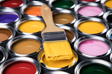 Metal tin cans with color paint and paintbrush