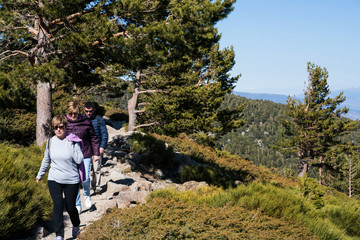 A bunch of friends in their 50's practice mountain hiking at spring time