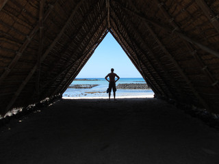 Silhouette of a man in a beach hut