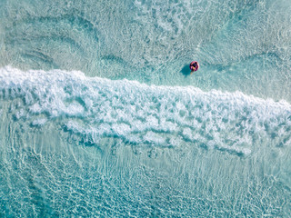 Aerial shot of swimmers on a beautiful beach with blue water and white sand © Andrew Atkinson