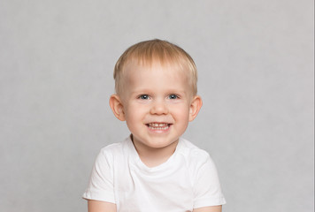 Fototapeta premium little cute toddler boy laughing provocatively on white background