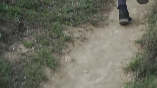 Young male trail runner with backpack training on the hill in sunny day 