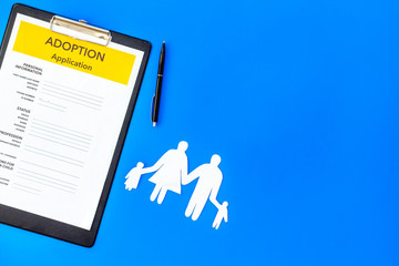 Adoption application near family figures on blue background top view copyspace