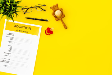 Children care with adoption application, dummy and toy on yellow background top view space for text