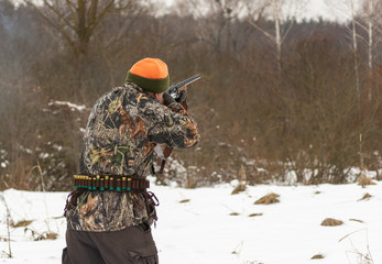 End of hunting season. Hunter shooting in the field.