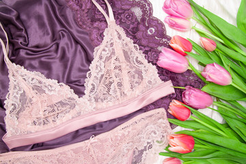 Flat lay, magazines. Top view Woman sexy fashion accessories panties and bra, underwear, purple background. and flowers tulips. Beauty blog concept.