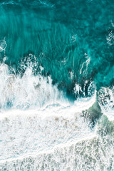 Aerial of a beach with waves at sunset with nice tones and warm summer vibes.