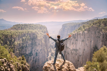 Obraz premium Young traveller enjoying a looking at sunset on Panoramic mountains view. Traveling, active lifestyle concept