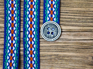 varicolored ribbon with embroidered ornament and old classic button