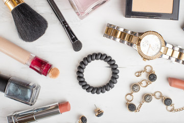 Beauty concept in a blog. Professional female make-up accessories: watches, bracelet, lipstick, brush, powder, on a marble background. Female background and fashion. Instagram, girly or women's things
