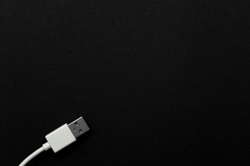 White USB cable in the lower left corner on a black background