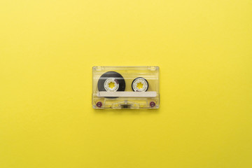 Old audio cassette in the center on yellow background. Place for text.