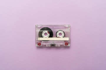 Close-up of an old audio cassette in the center on purple background. Place for text.
