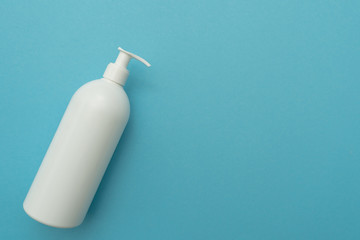 White plastic bottle of liquid cosmetic(soap, shampoo, lotion) with a dispenser in the lower left...