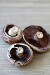 Beautiful champignon mushrooms on a wooden table. Selective focus.