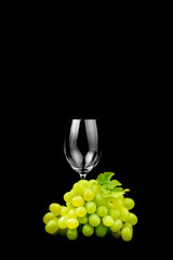 Glass of wine and grape on black background